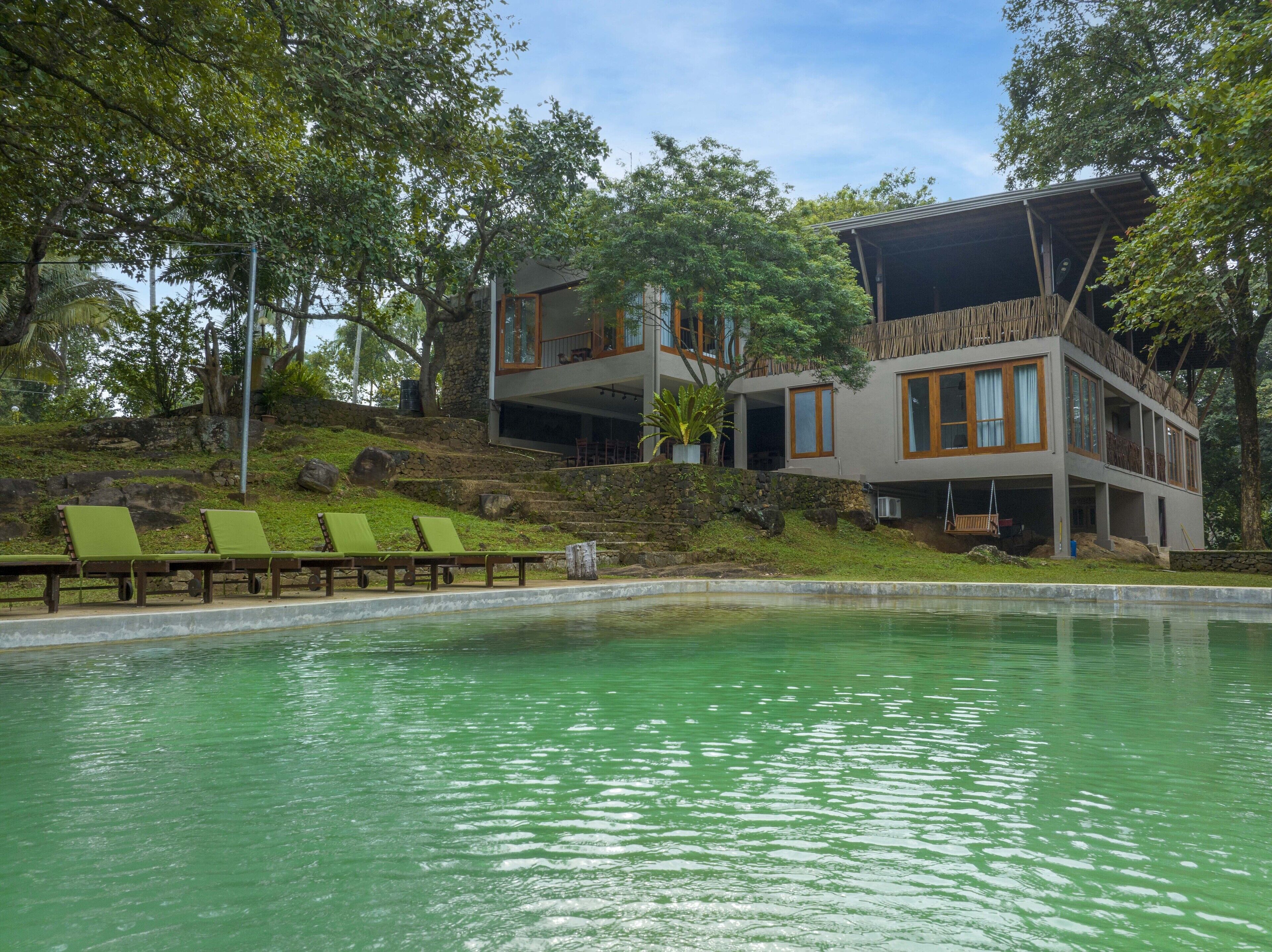 A modern two-story building with a pool in the foreground.
