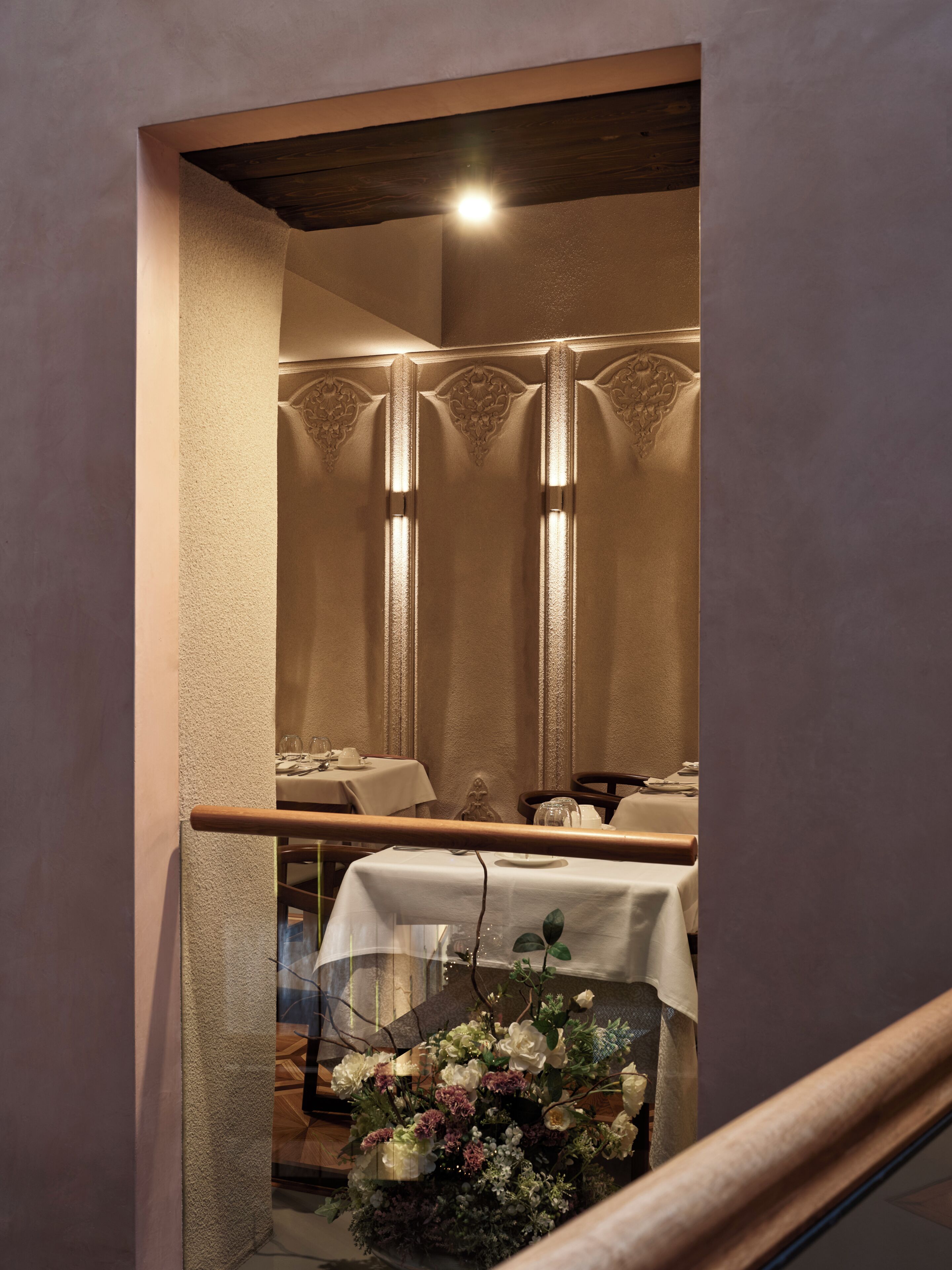 Un comedor con mesas, sillas y un centro de mesa floral.