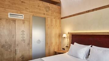 Una habitación con paneles de madera, una cama, una mesita de noche y una lámpara de pared.