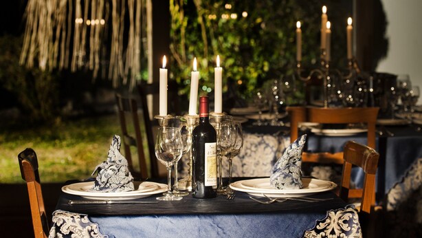 A table set for two with wine glasses, a bottle of wine, and candles. - La Vignola Country Hotel (Ceprano)