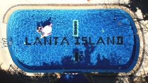 Ein Schwimmbecken mit den Schriftzügen 'LANTA ISLAND' auf der Fliesenoberfläche.