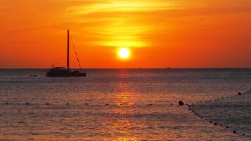 Atardecer sobre el océano con un velero.