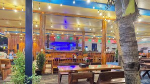 Ein Restaurant mit Holzkubaturen, einer Bar und Lichterketten.