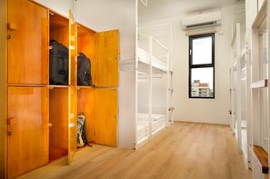 A room with wooden wardrobes, a bunk bed, and a window with a view of buildings. - Onederz Hostel Siem Reap (Siem Reap)