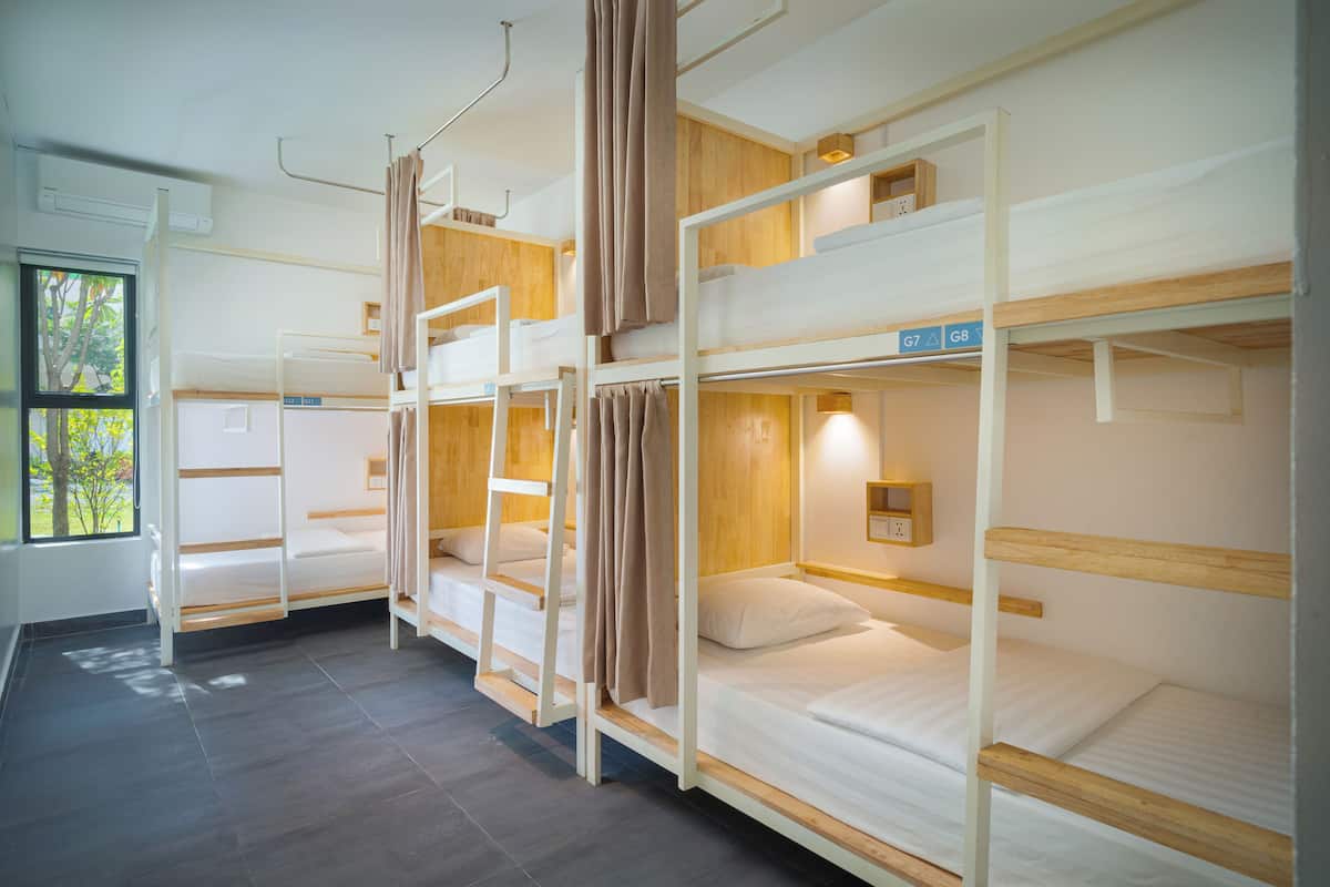 Un dormitorio con literas, una ventana y una lámpara fijada a la pared.