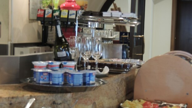 A buffet setup with various food items, utensils, and condiments. - Hotel Club (Kezmarok)