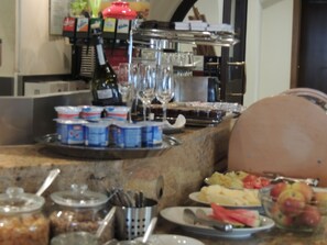 A buffet setup with various food items, utensils, and condiments. - Hotel Club (Kezmarok)