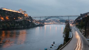 Un río con un puente, barcos y una carretera con estelas de luz.