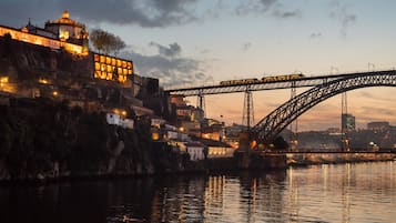 Un puente sobre un río, con edificios a la izquierda y un faro a la derecha.