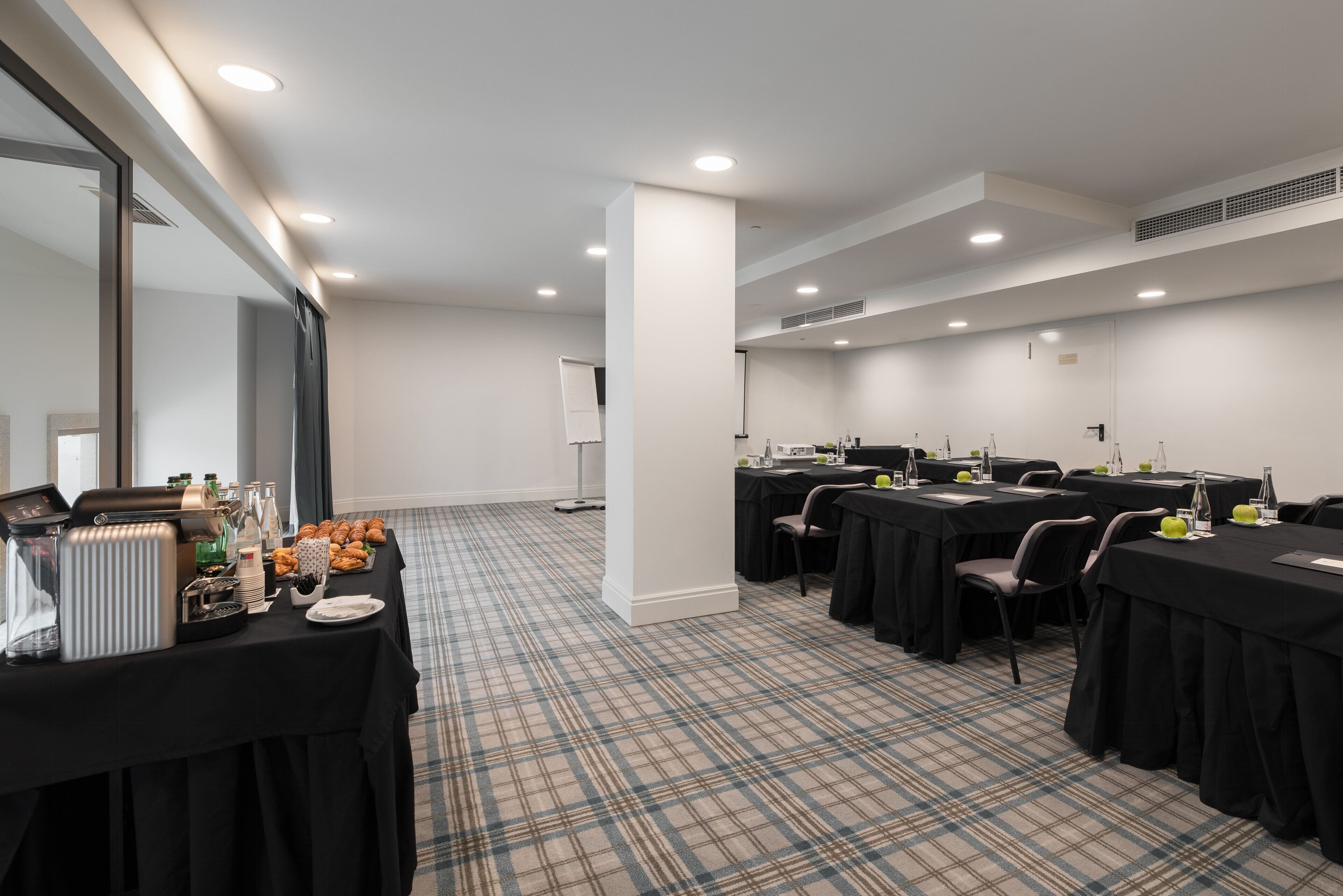 Ein Konferenzraum mit Tischen, Stühlen und einem Buffet.