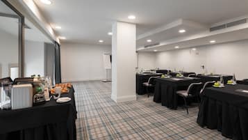 A conference room with tables, chairs, and a buffet setup.