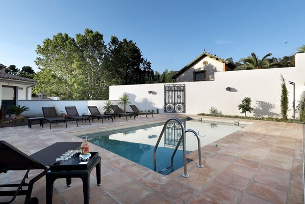 A pool area with lounge chairs, a pool table, and a clear sky. - Áurea Washington Irving by Eurostars Hotel Company (Granada)
