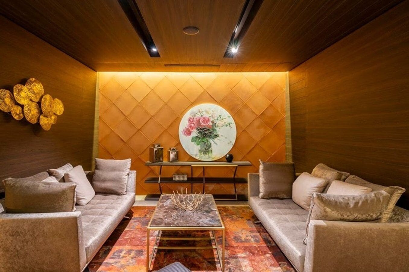 Una sala de estar acogedora con dos sofás, una mesa de centro y un panel decorativo en la pared.