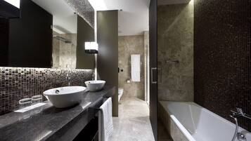 Ein modernes Badezimmer mit einer großzügigen Badewanne, einem Doppelwaschbecken mit Hängebecken und einer Duschkabine.