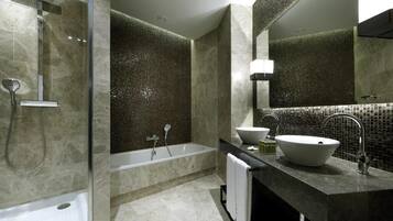 A modern bathroom with a glass-enclosed shower, a freestanding bathtub, a vanity with a large sink, and a mirror above the sink.