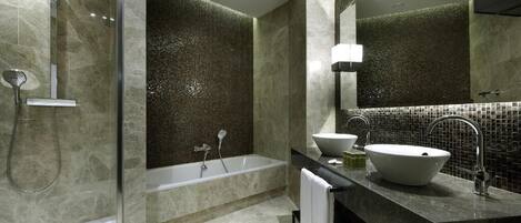 A modern bathroom with a glass-enclosed shower, a freestanding bathtub, a vanity with a large sink, and a mirror above the sink.