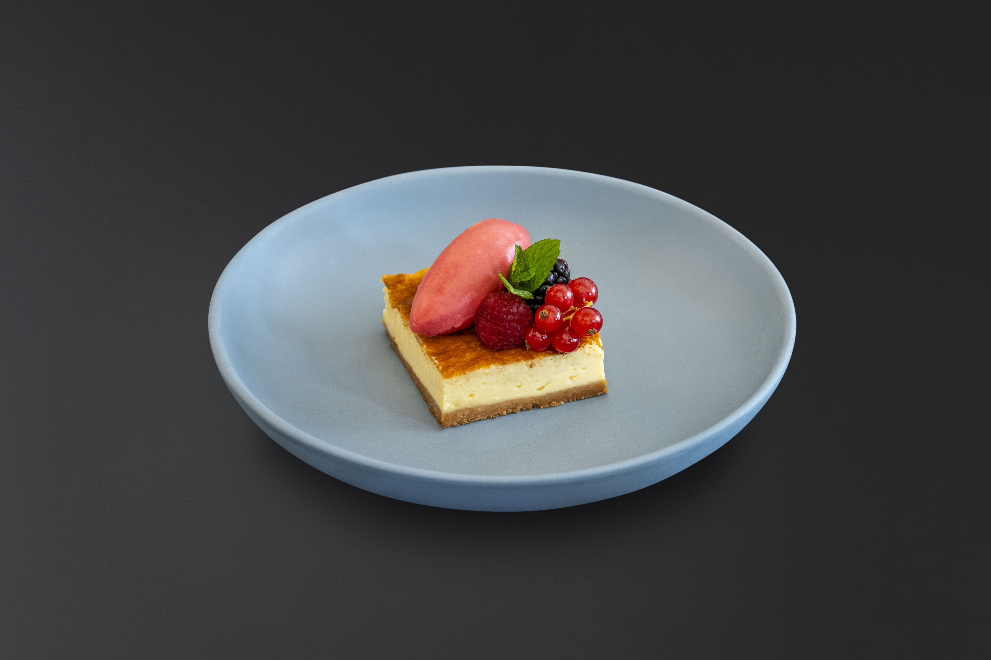 A dessert on a blue plate with a dark background.