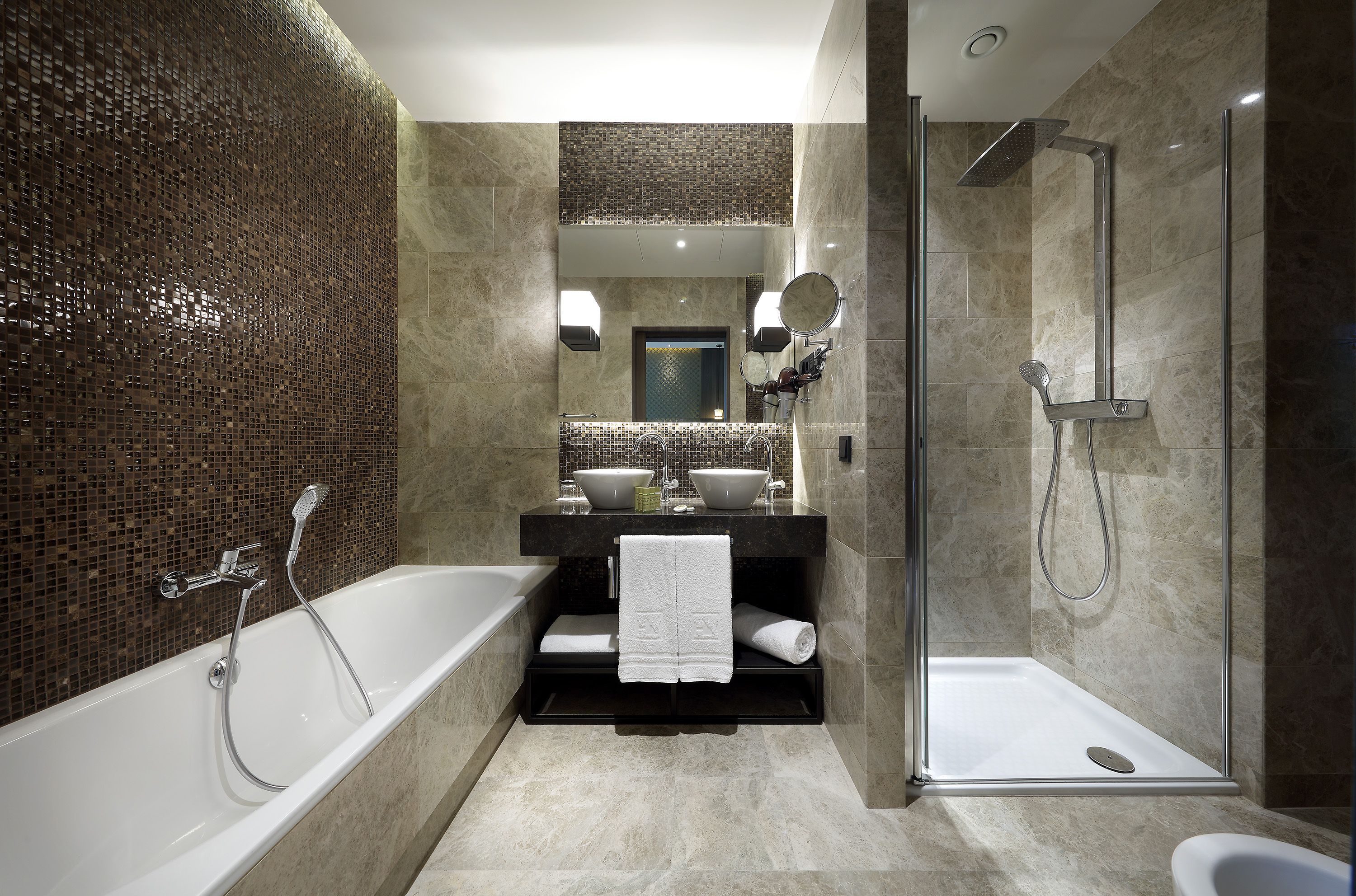 A modern bathroom with a freestanding bathtub, a glass-enclosed shower, and a vanity with two sinks.