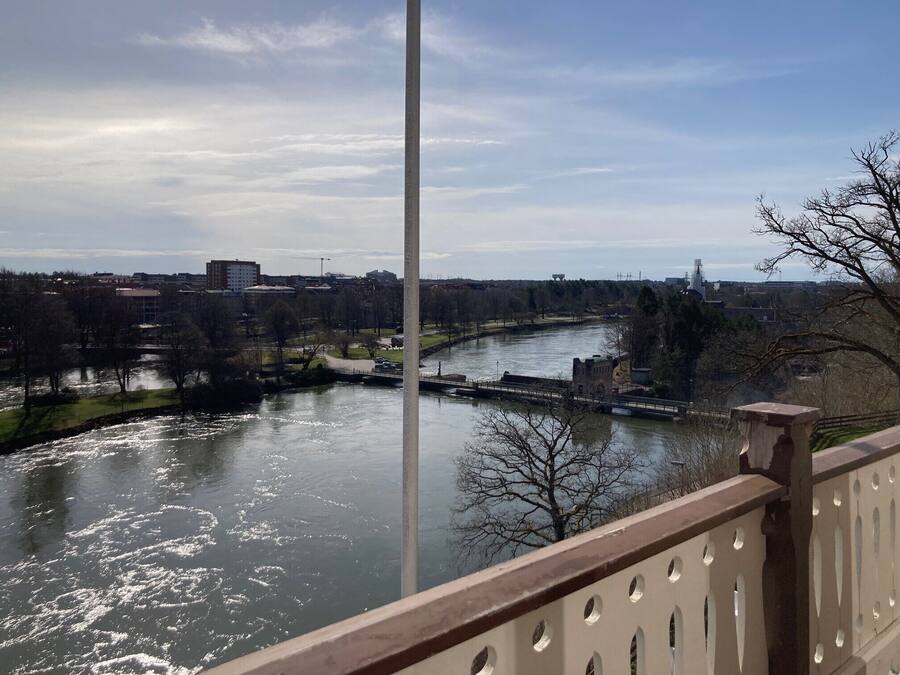 A river with a bridge, trees, and buildings in the background.