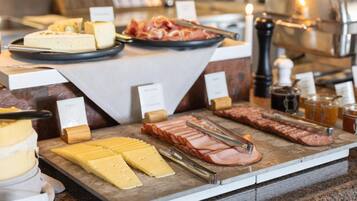 Ein Buffet mit verschiedenen Käsesorten, Fleischwaren und Beilagen.