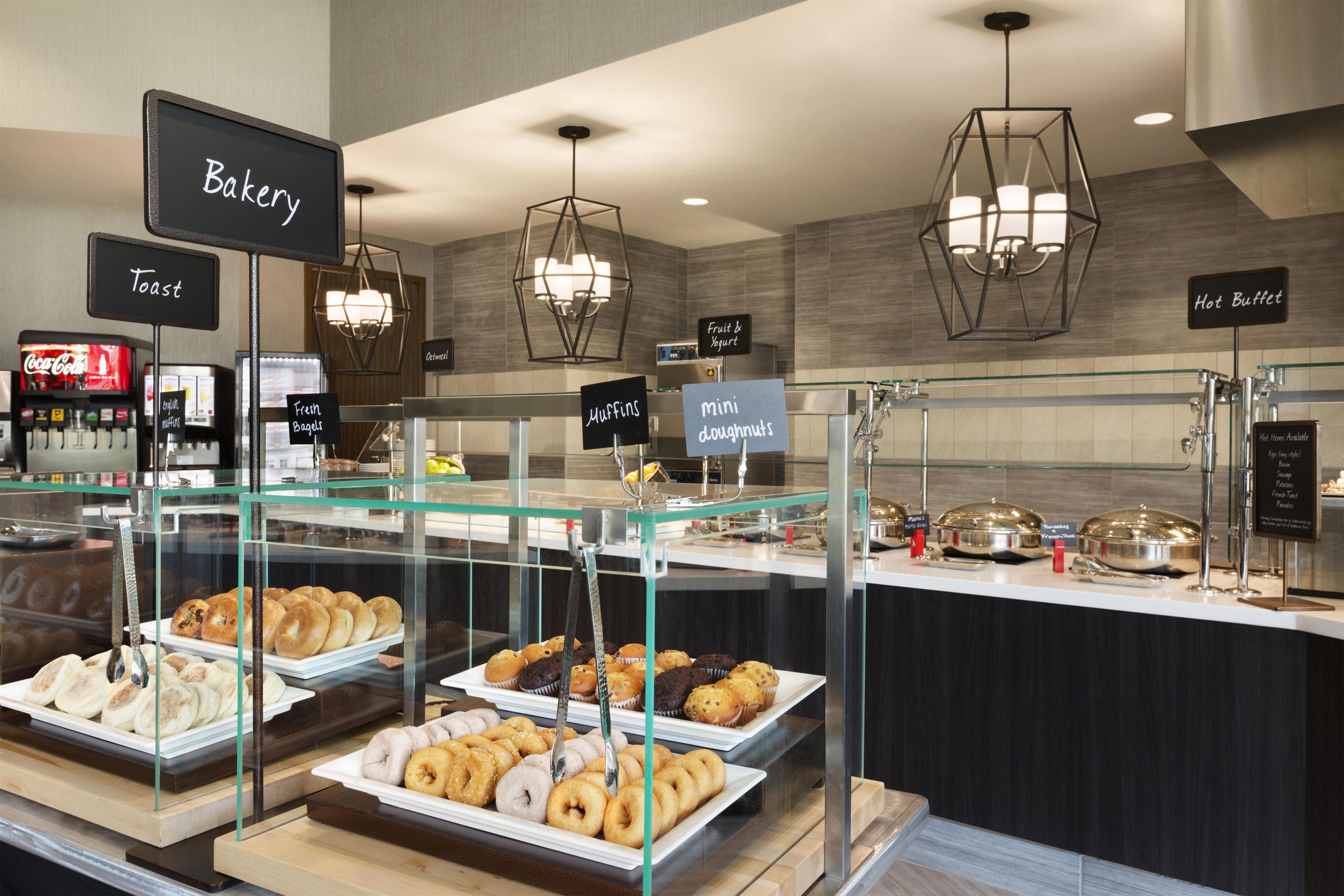 A bakery section with various baked goods displayed in glass cases, including muffins, bagels, and doughnuts.