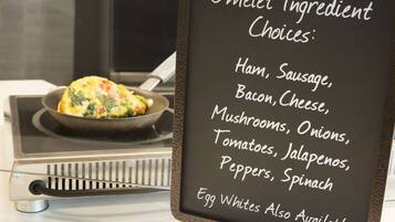 A menu board listing omelet ingredient choices such as ham, sausage, bacon, cheese, mushrooms, onions, tomatoes, jalapenos, peppers, spinach, and egg whites.