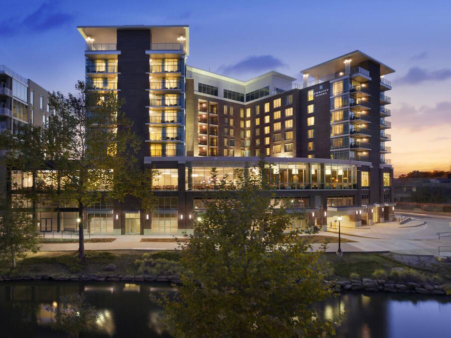 A multi-story hotel with a modern architectural design, featuring balconies and large windows.