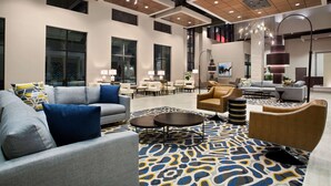 A spacious lobby with modern furniture, a patterned carpet, and a high ceiling with recessed lighting. - Embassy Suites by Hilton McAllen Convention Center (McAllen)