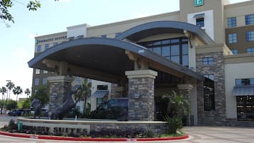 A hotel entrance with a covered driveway, a sign for 'Embassy Suites', and a fire lane curb.