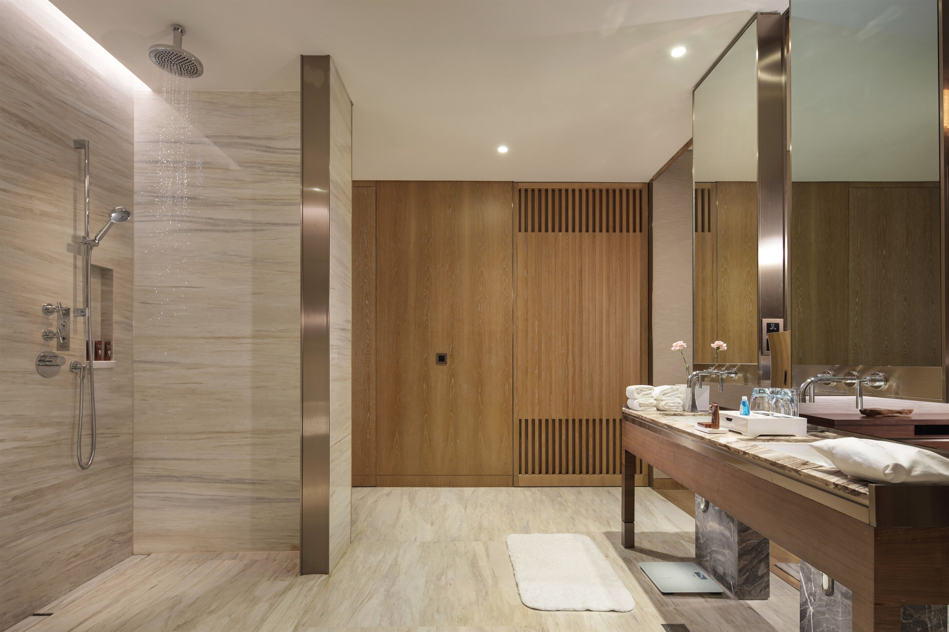 A modern bathroom with a shower, vanity, and a large mirror.