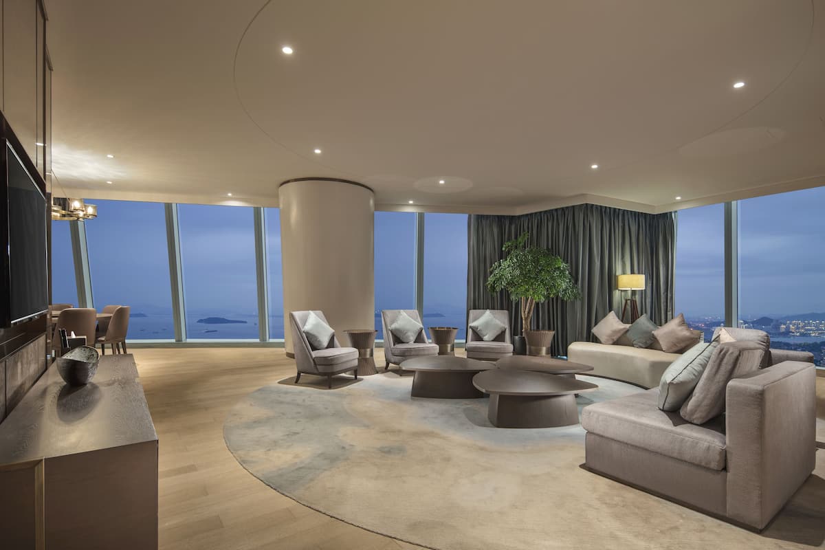 A spacious living room with a large window, a round coffee table, and a sofa.