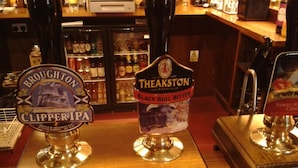 Two beer taps labeled 'Broughton Clipper IPA' and 'Theakston Black Bull Bitter' in a bar setting.
