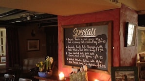 A chalkboard menu listing specials like braised steak and grilled salmon.