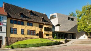A modern building with a traditional yellow facade and a contemporary grey structure. - Hotel Bamberger Hof (Wutha-Farnroda)