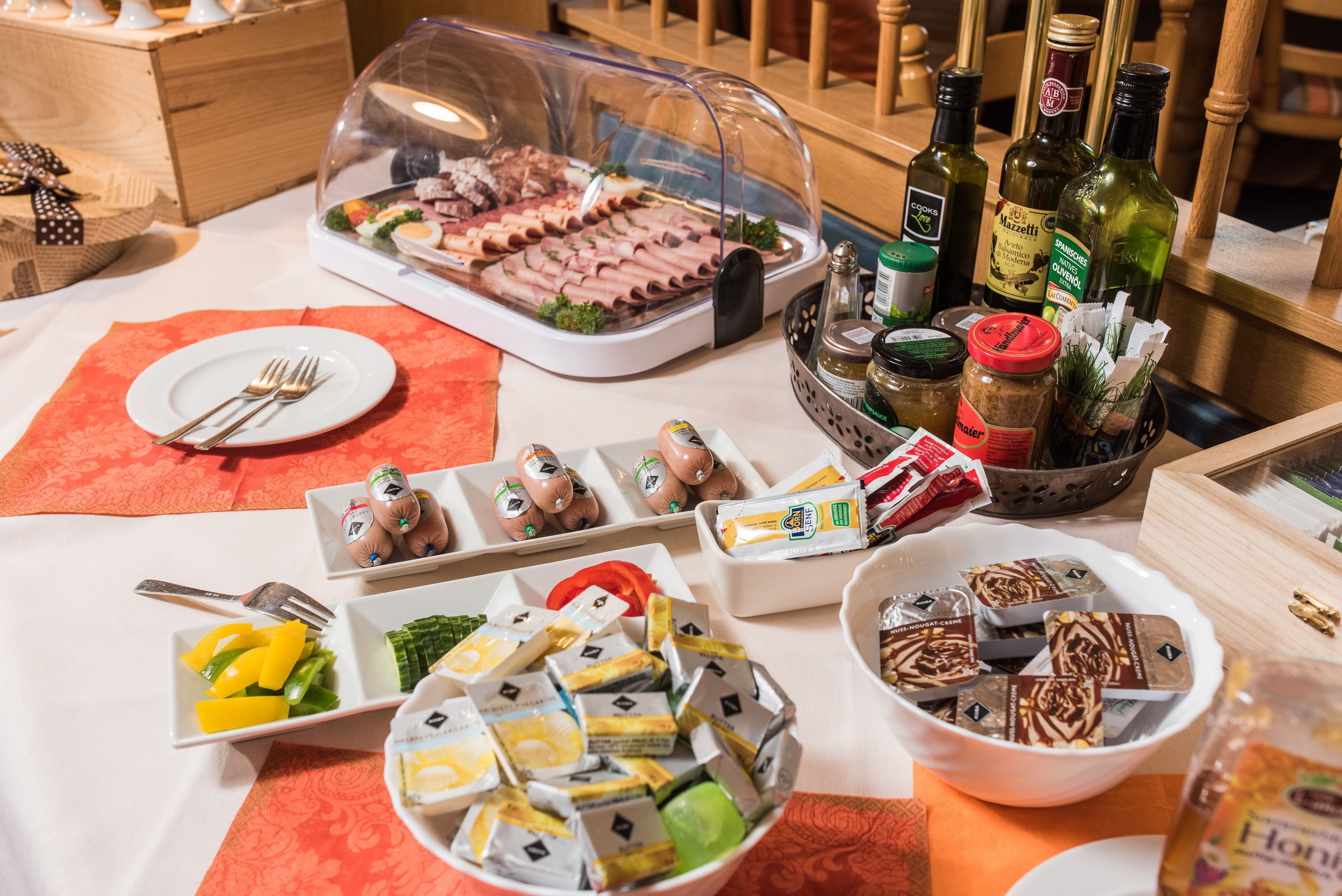 Une table de buffet proposant une variété de plats, notamment des viandes, des fromages et des condiments.