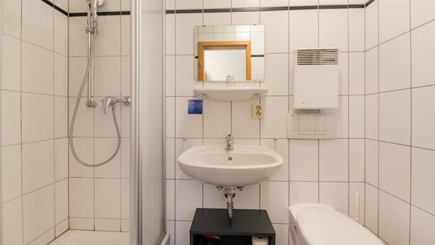 A bathroom with a shower, sink, and toilet. - Hotel Bamberger Hof (Wutha-Farnroda)