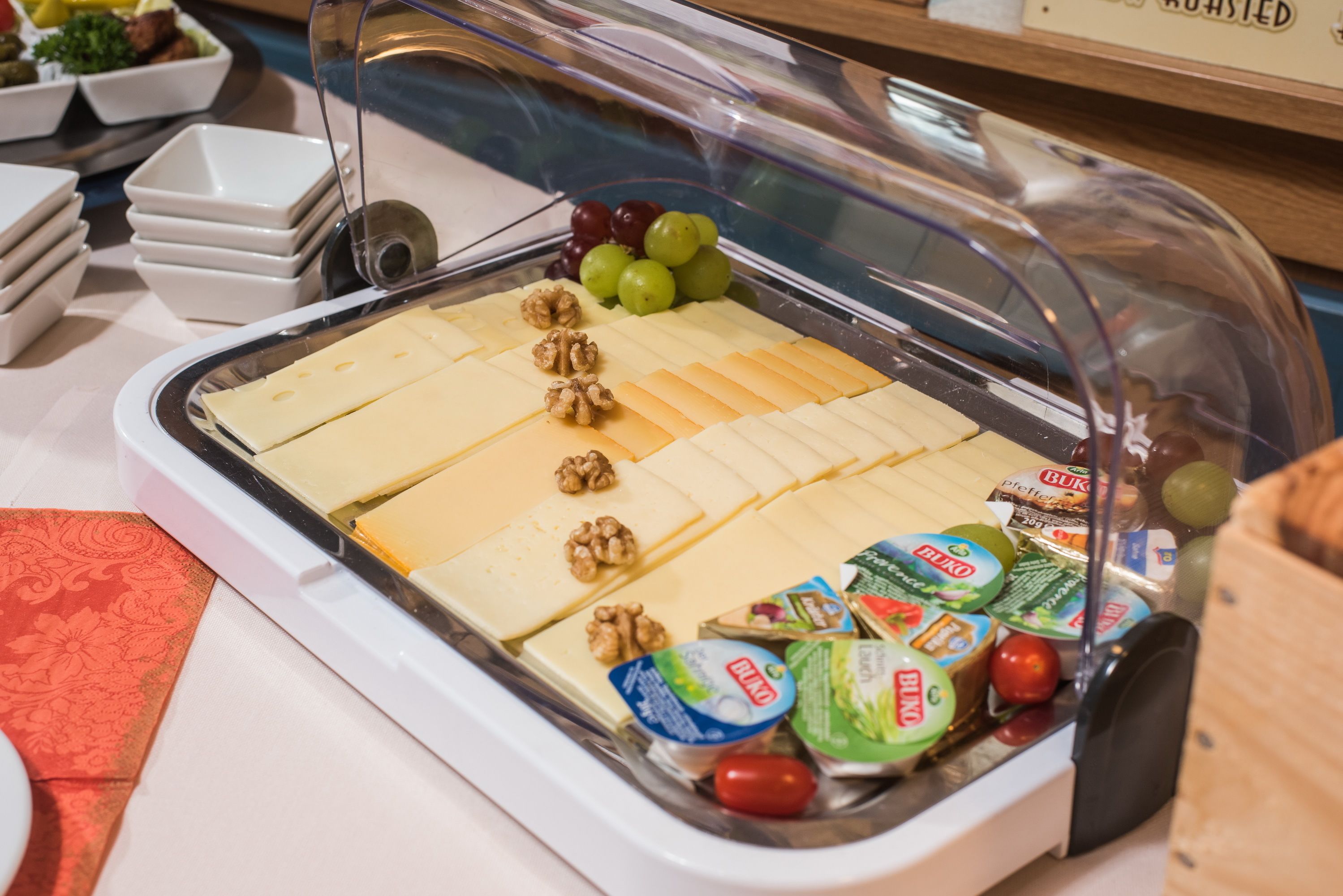 A buffet with various cheeses, walnuts, and packaged foods.