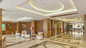 A spacious lobby with a polished marble floor, wooden paneling, and a seating area with sofas and armchairs. - Lamec Hotel Business (Gebze)