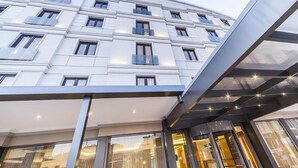 A modern hotel facade with a curved design, large windows, and a glass entrance. - Lamec Hotel Business (Gebze)