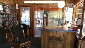 L’intérieur d’un motel accueillant, avec des meubles en bois, un comptoir d’accueil et une vue sur le parking.