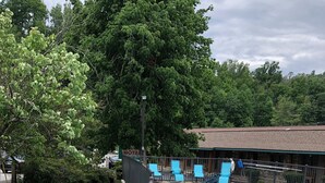 Une piscine entourée d’une clôture, une enseigne de motel et un petit ruisseau.