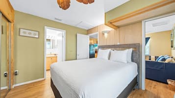 Une chambre avec un grand lit, un plafond en bois et une vue sur la cuisine.