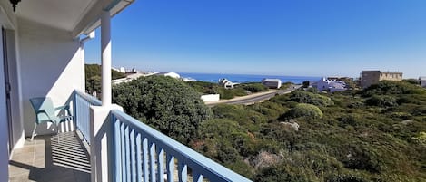 Un balcón con vista al océano y la vegetación circundante.