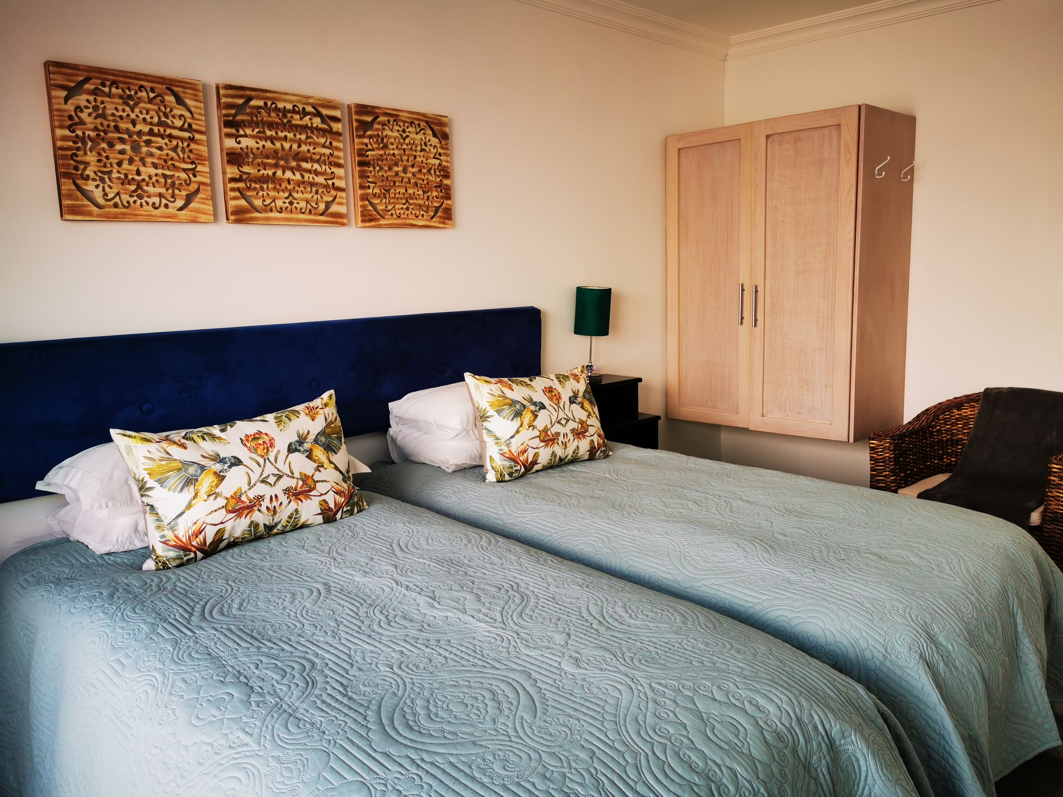 Ein Schlafzimmer mit zwei Betten, einem großen Kleiderschrank und Wanddekoration.