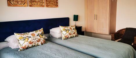 Ein Schlafzimmer mit zwei Betten, einem großen Kleiderschrank und Wanddekoration.