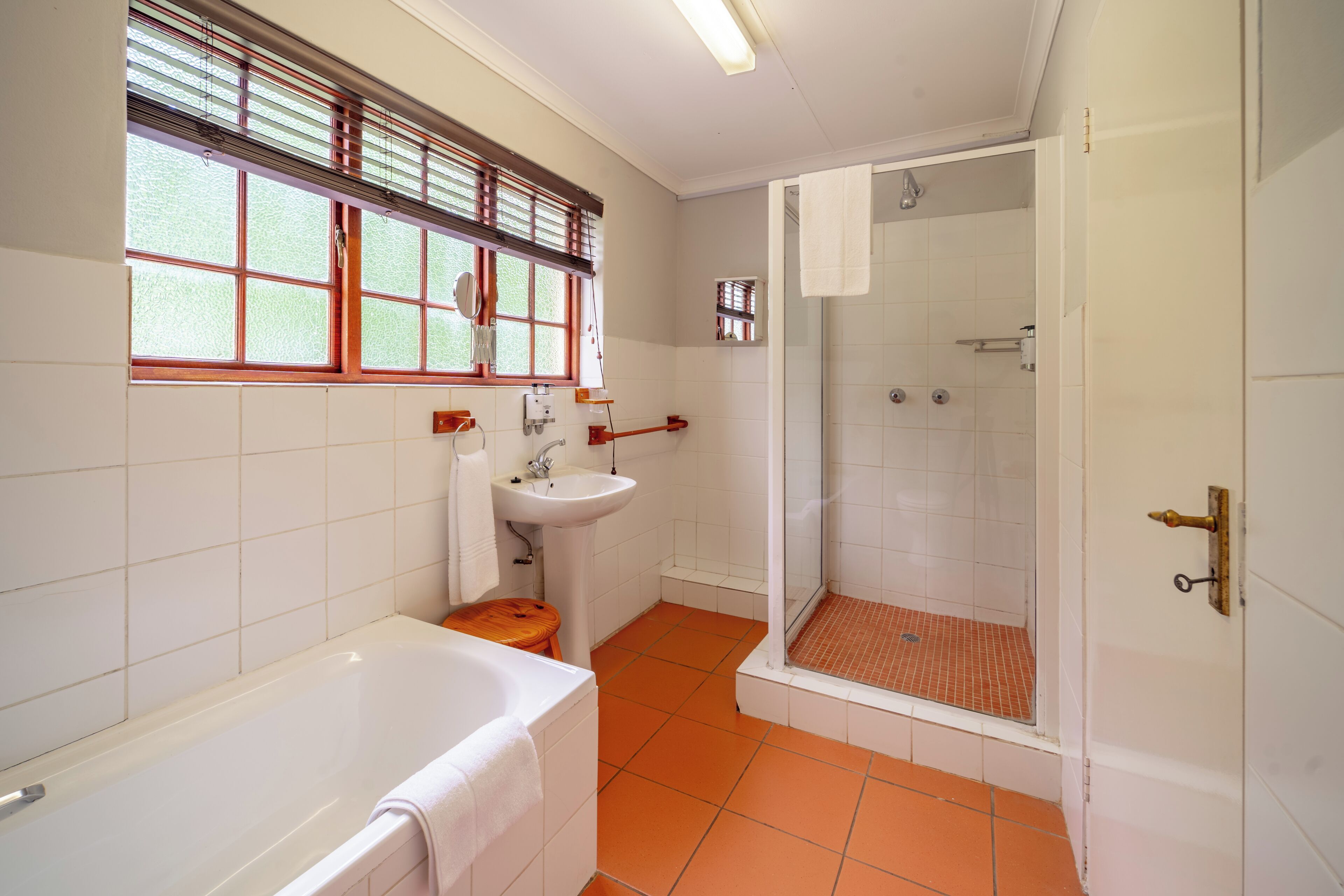 A bathroom with a bathtub, sink, and shower.