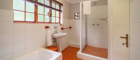 A bathroom with a bathtub, sink, and shower.