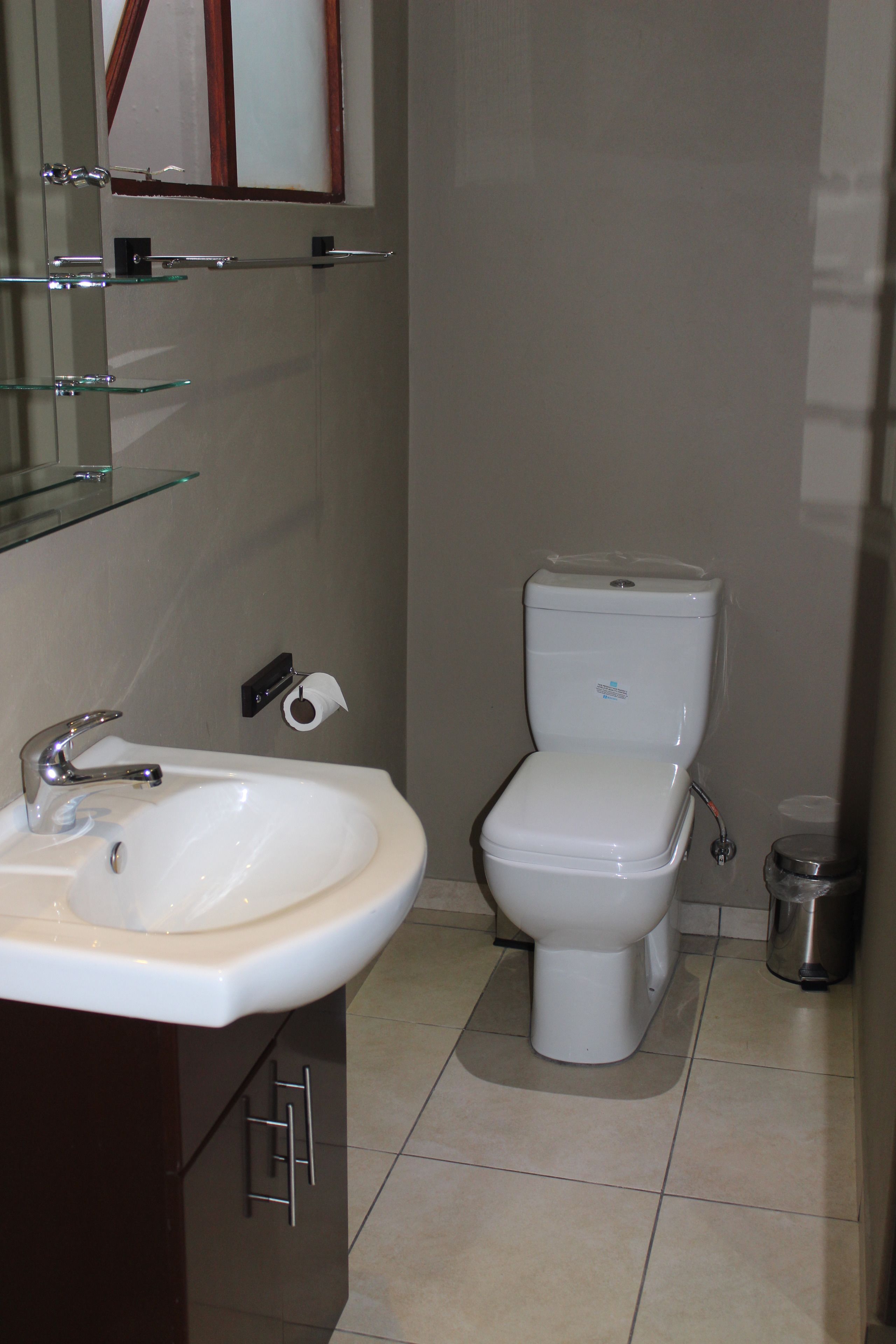 Un baño con lavamanos, espejo y retrete.