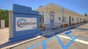 A motel named WhiteCaps with a signboard, a covered parking area, and a building with an 'Office' sign. - White Caps Motel (Ventura)