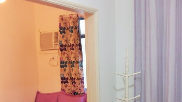 Ein Schlafzimmer mit Bett, Stuhl, Kleiderschrank und Heizkörper.